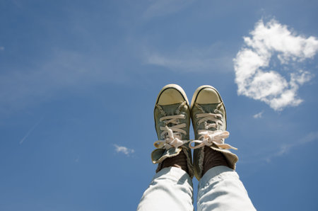Feet with cowboy shoes stepping on the sky