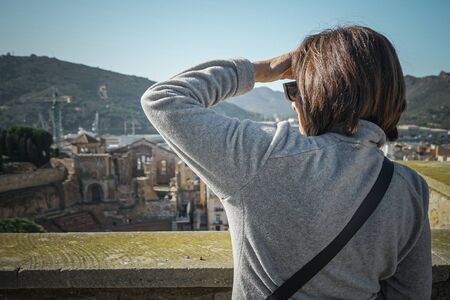 Woman looking towards the Roman Theater of Cartagena. Murcia. Spainの写真素材