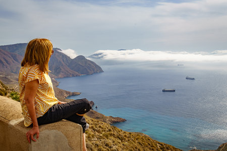 Woman contemplating the Mediterranean sea from the top of the hillの写真素材
