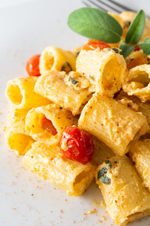 Dish of maccheroncini pasta with cherry tomatoes and ricotta sauceの写真素材