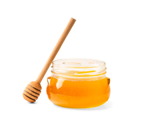 Fresh honey in a jar with a wooden dipper on a white isolated background.Honey in an open glass jar with a honey stick. Honey in a jar on a white background.の写真素材