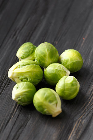 A handful of Brussels sprouts on a wooden background. Fresh cabbage on a dark background. Products for vegans. Useful vegetables. diet for vegetarians.の写真素材