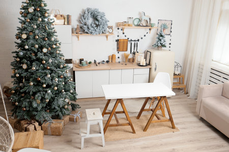 Christmas tree on the background of the kitchen. Beautiful modern Christmas decor. Concept of New Years, Christmas. Winter holidays, gifts, festive evening.Cooking food in the kitchenの写真素材