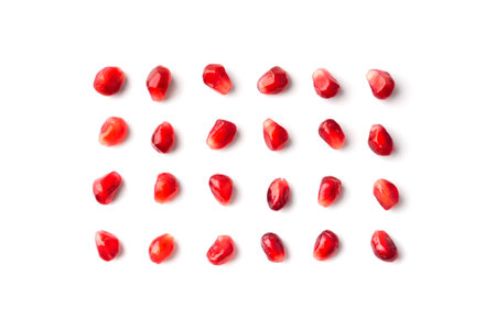 Red grains of a ripe pomegranate are neatly laid out on a white background top view. Pomegranate grains isolated. Background of pomegranate seeds.の写真素材
