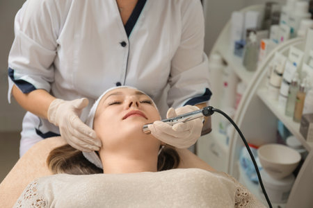 face treatments. The concept of maintaining health, youth and beauty. Modern cosmetology, beautician tools, hands with gloves. hardware cosmetology. face lifting. Anti-aging cosmetic procedures.の写真素材