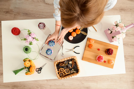 handmade soap. Home made soap look like cake with berries on light background. Natural homemade cosmetics and handmade soaps concept. The girl is holding a homemade muffin in her hands top view.の写真素材