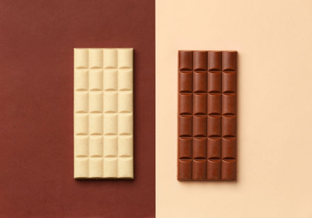 White chocolate bar on a brown background, milk chocolate bar on a beige background top view, chocolate on contrasting backgrounds.の写真素材