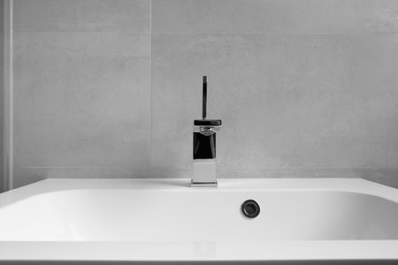 Modern bathroom interior, white washbasin with drawers, chrome faucet, socket and switch on the wall. Bathroom interior with sink and faucet.の写真素材