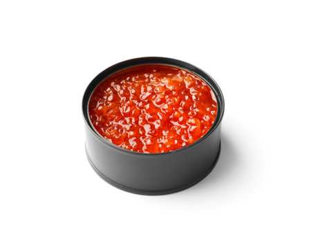 Red salmon caviar in an open black tin can on a white background. Useful delicacy seafood, canned fish.の写真素材