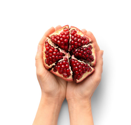 Ripe peeled pomegranate in hands on a white background top view. A whole pomegranate with a cut peel in the palms on the isolation. healthy fruits.の写真素材