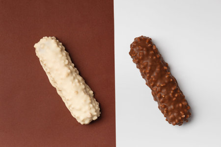 White and dark chocolate on brown and white background, top view. Conceptual representation of two...