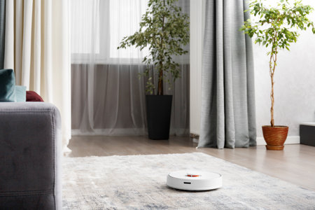 Smart robot vacuum cleaner in a modern living room interior. The concept of a smart home, wireless cleaning by a robot with a vacuum cleaner of any surfaces.の写真素材