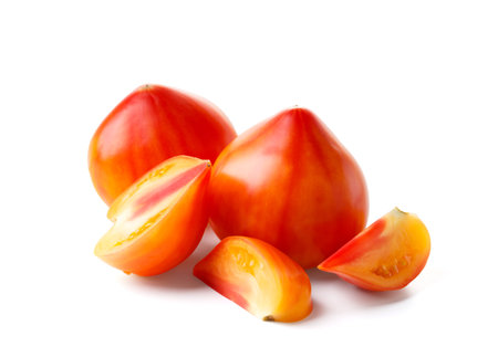Whole and cut large organic striped yellow-red tomatoes isolated on white background, close-upの写真素材