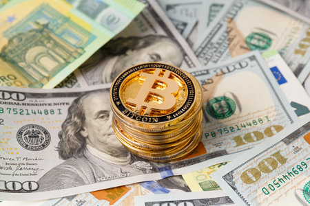 Bitcoins, banknotes of 100 dollars and 100 euros close-up as a background. The concept of finance, business, wealth, success, cryptocurrency.の写真素材