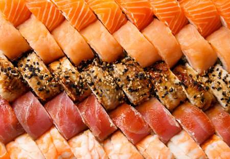 A large set of sushi rolls with shrimp, salmon, tuna, eel, top view, close-up. Sushi delivery. Rolls as a background.の写真素材