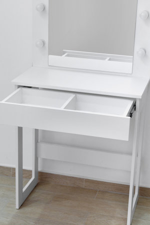 Close-up of part of a white dressing table with an open drawer. Makeup artist workplace, dressing room, modern dressing table.の写真素材