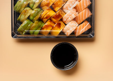 A set of bright multi-colored sushi rolls with shrimp, salmon, avocado in plastic packaging on a light background, top view. Sushi deliveryの写真素材