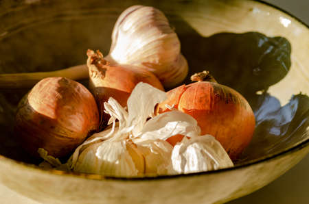 Close up shoot of onions and garlic in the bowlの写真素材