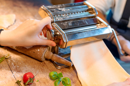 Close-up of the hands of a woman preparing a pizza.の写真素材