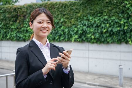 Young businesswoman searching for a destination with her smartphoneの写真素材