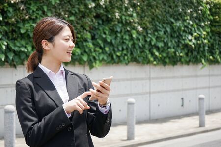 Young businesswoman searching for a destination with her smartphoneの写真素材