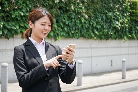 Young businesswoman searching for a destination with her smartphoneの写真素材