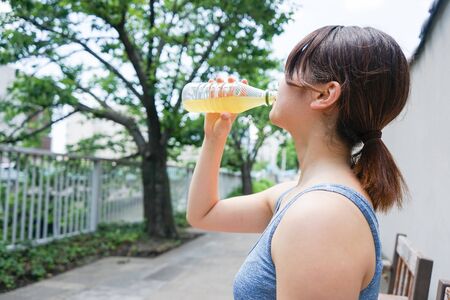 Young woman staying hydrated during sportの写真素材