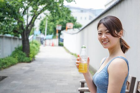 Young woman staying hydrated during sportの写真素材