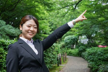 Businesswoman pointing to upside outdoorsの写真素材