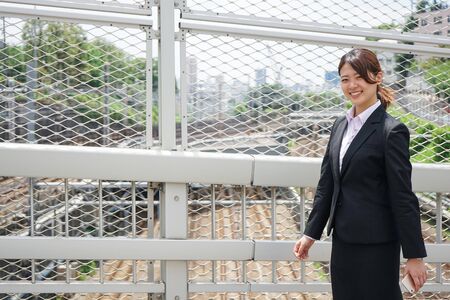 Businesswoman walking outdoors with smileの写真素材