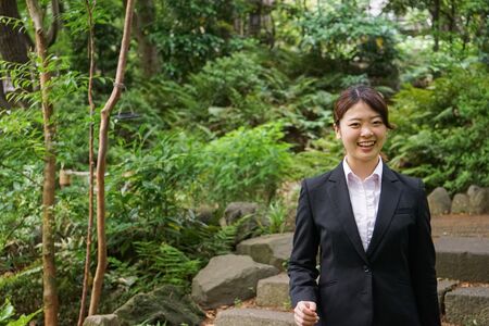 Businesswoman walking outdoors with smileの写真素材