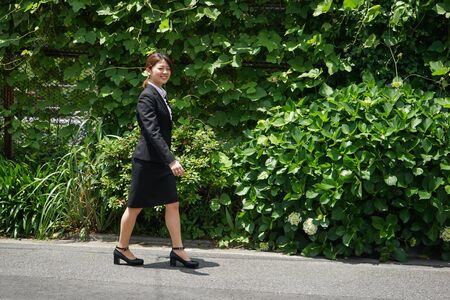 Businesswoman walking outdoors with smileの写真素材