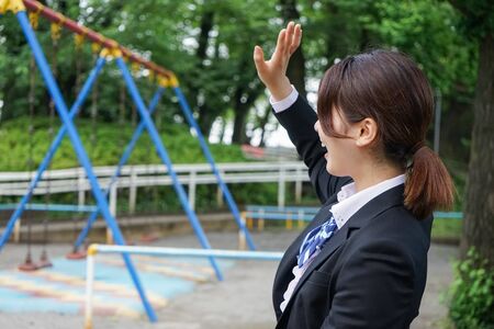 Student waving her hands with smileの写真素材
