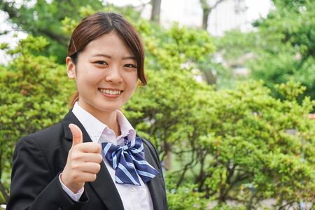 Student waving her hands with smileの写真素材