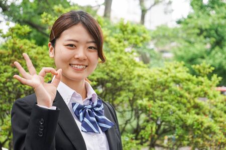 Student waving her hands with smileの写真素材