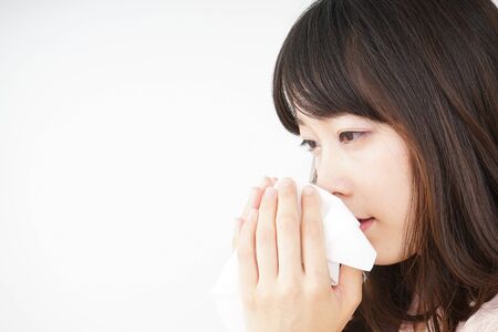 Young woman blowing her noseの写真素材