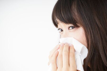 Young woman blowing her noseの写真素材