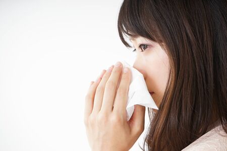 Young woman blowing her noseの写真素材