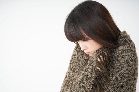 Young woman developing a fever because of a coldの写真素材