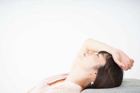 Young woman getting lying down because of poor healthの写真素材