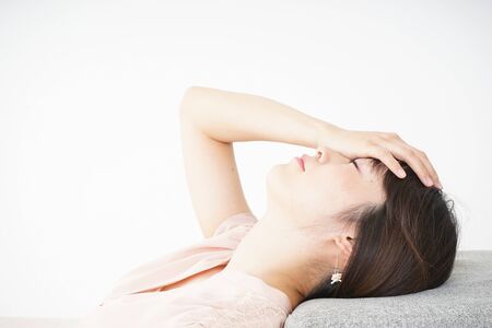 Young woman getting lying down because of poor healthの写真素材