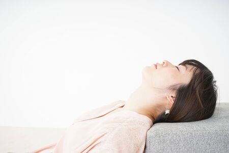 Young woman getting lying down because of poor healthの写真素材
