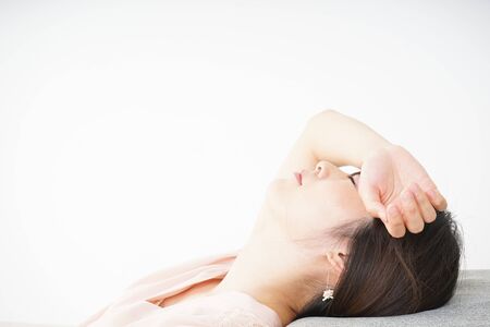 Young woman getting lying down because of poor healthの写真素材