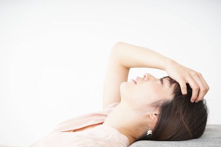 Young woman getting lying down because of poor healthの写真素材