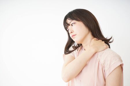 Young woman feeling stiff in her shouldersの写真素材