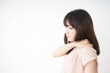 Young woman feeling stiff in her shouldersの写真素材