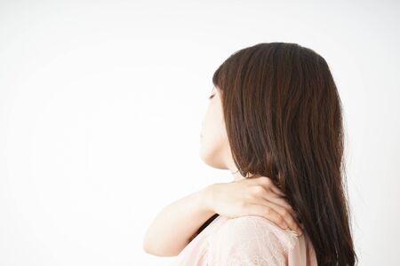 Young woman feeling stiff in her shouldersの写真素材