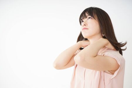 Young woman feeling stiff in her shouldersの写真素材