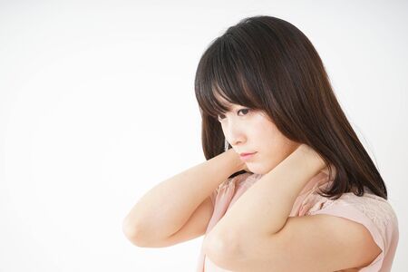 Young woman feeling stiff in her shouldersの写真素材