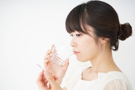 Young woman taking oral medicineの写真素材